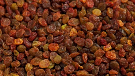 looped spinning full frame background of yellow and brown raisins pile