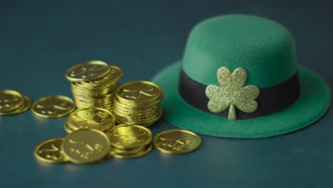 foto de estudio de sombrero de copa de duende verde y montones de monedas de oro para celebrar el día de san patricio 9