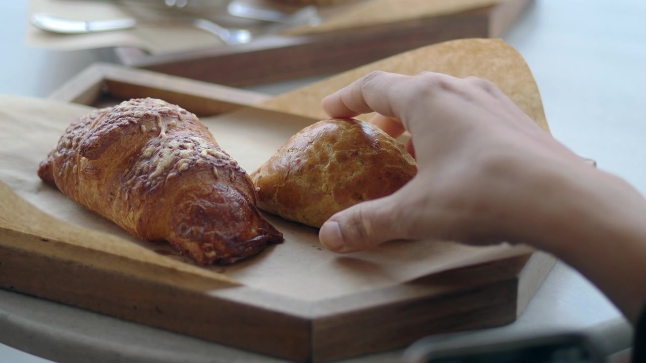 Mano che prende un dolce appena sfornato da un vassoio di legno