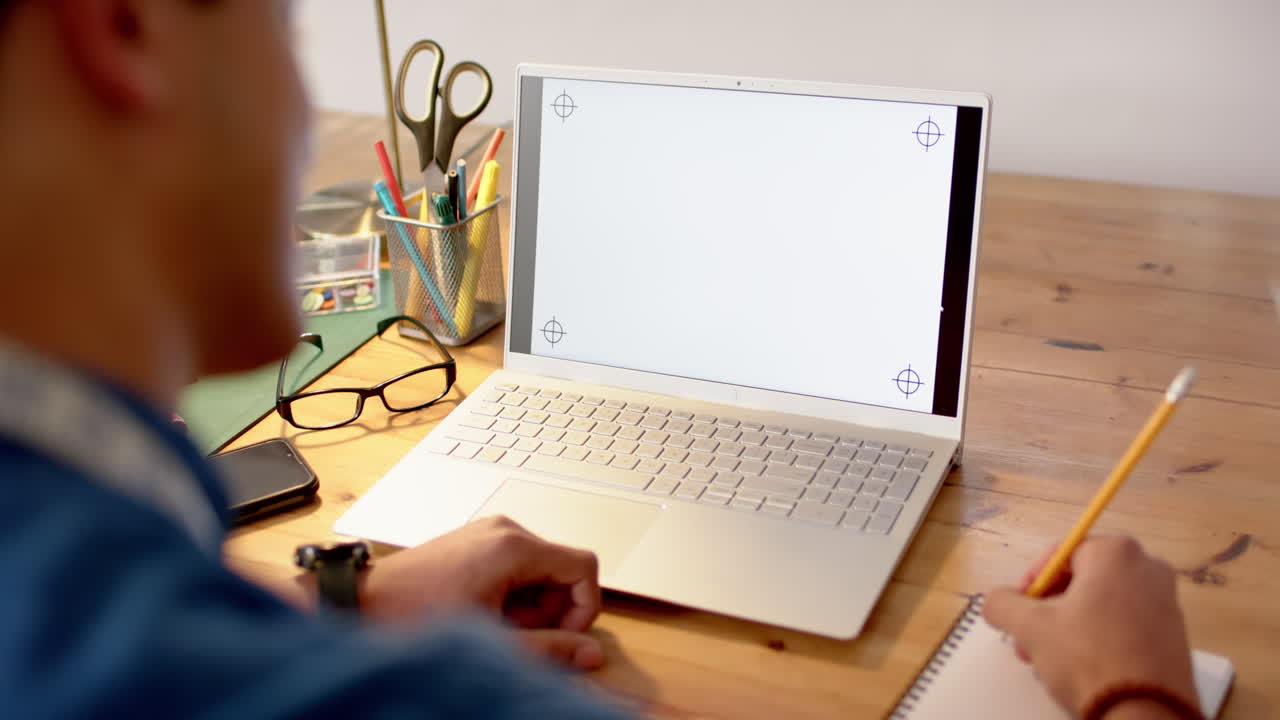 Biracial male fashion designer sketching design at desk using laptop with copy space, slow motion