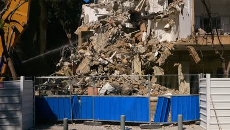 spraying water at construction site during building demolition for dust control