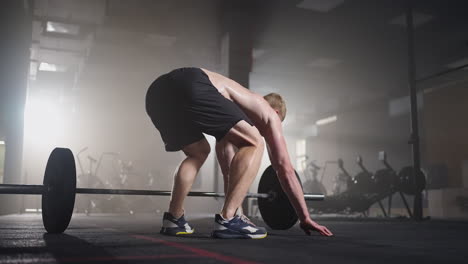 fitness man doing burpee workout at gym. medium shot of young man doing push ups and jump exercise in slow motion. sport concept