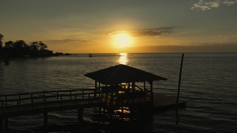 silhouette of people walking on a dock at sunset on mobile bay, alabama