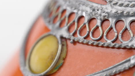 close up of rotating metal jewelry on white background