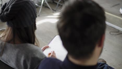 Closeup-view-of-young-workers-taking-notes-during-the-presentation.-View-from-the-back.-Shot-in-4k.