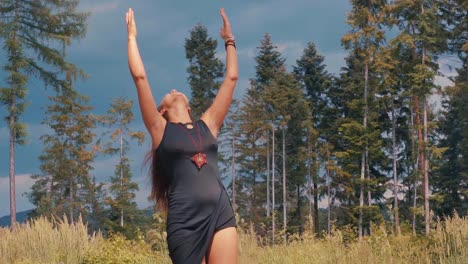 free spirited hippie woman with hands up on sunny day alone in forest, slowmo