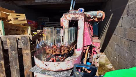 old rotary bottling machine or bottle filler at rural farm site storage place