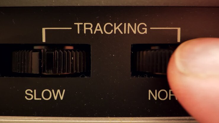 Primo piano estremo di un pulsante su un videoregistratore vintage che regola il pulsante Tracking.