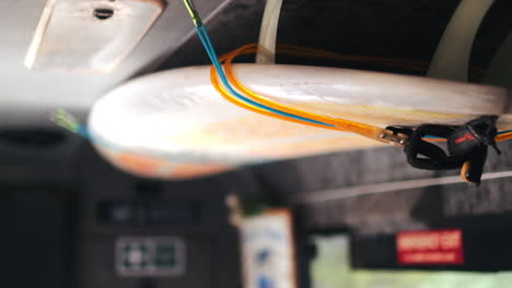 Close-up-shot-of-hanging-surfboard-in-bus,-ready-for-holiday-surf-trip-in-summer