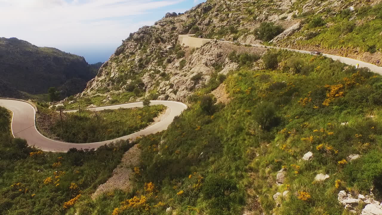 Vista aerea che si innalza su strade tortuose di montagna con veicoli sull'isola di Maiorca