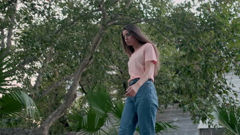 young girl model walking with tropical plants on background