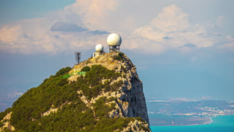 Radar-antenna-radomes-on-the-point-of-the-mountain-at-the-Gibraltar-cable-car-top-station---daytime-cloudscape-time-lapse