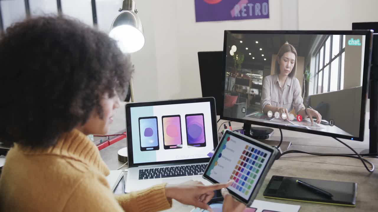 mujer de negocios afroamericana en videollamada con una colega caucásica en la pantalla