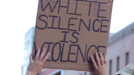 BLM-placard-sign-is-raised-overhead-at-peaceful-demonstration-march