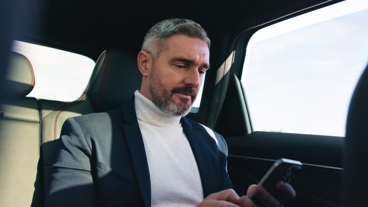 A man using a cell phone inside a car