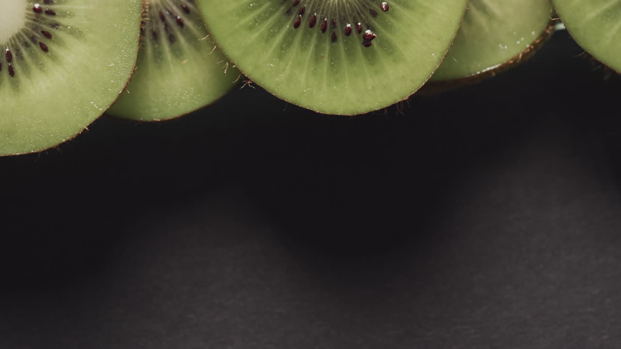 micro vídeo de close-up de fatias de kiwi com espaço de cópia em fundo preto