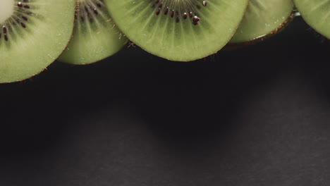 micro vídeo de primer plano de rebanadas de fruta de kiwi con espacio de copia en fondo negro