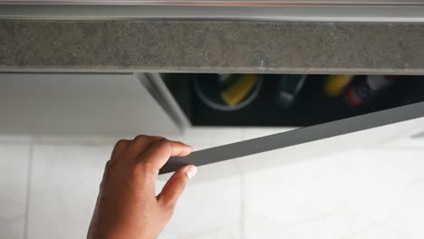 person opening a kitchen drawer