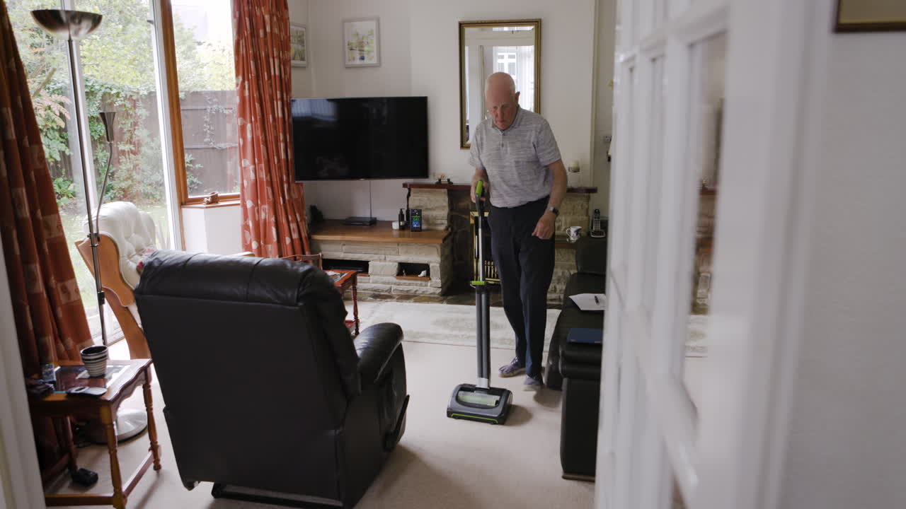 거실 에서 진공청소기 를 사용 하는 사람
