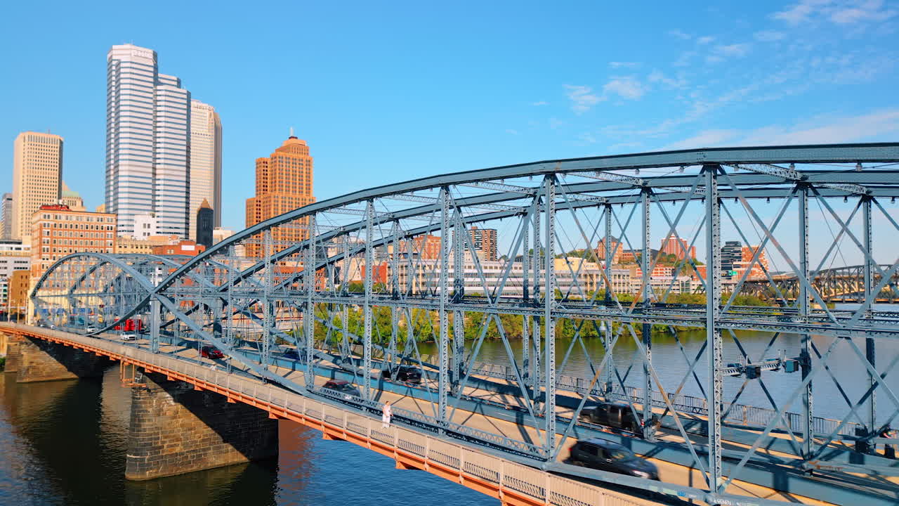 Red bus crosses the Smithfield-street Bridge in Pittsburgh, Pennsylvania, USA. Drone footage approaching the structure over the riverscape. Pittsburgh, Pennsylvania, USA