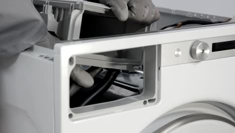 removing rubber tubes that connect to detergent drawer