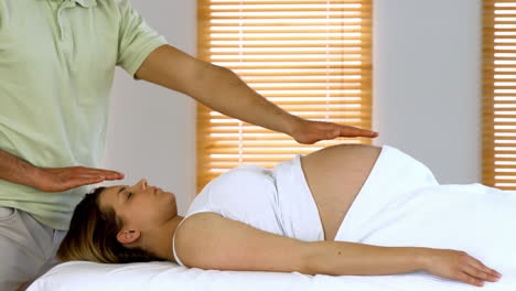 therapist performing reiki on patient