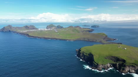 Mesmerizing aerial view of Vestmannaeyjar on a superb sunny summer day, calm waves washing the shoreline