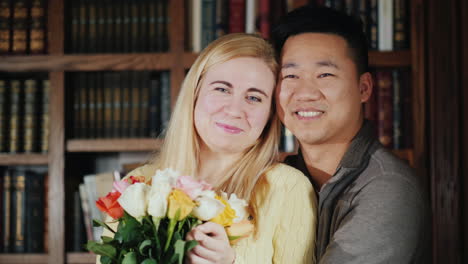 Portrait-Of-A-Young-Multi-Ethnic-Couple-A-Woman-Holding-Flowers