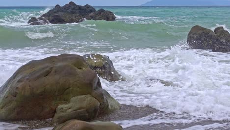 Olas-Del-Océano-En-Cámara-Lenta-Rompiendo-Sobre-Rocas-En-La-Playa-De-Banbanon-En-Surigao-Del-Norte,-Filipinas