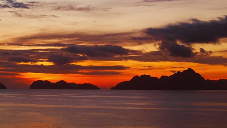 Spectacular sunset paints El Nido horizon with blazing clouds and calm sea
