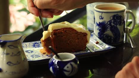 close up of eating a piece of carrot cake with a dainty cake fork for breakfast