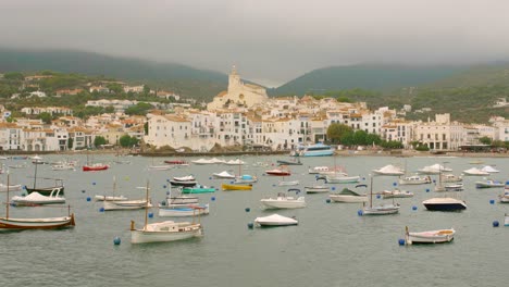 boats on the seaport and the santa maria de cadaques church in the old town of cadaques, girona, spain