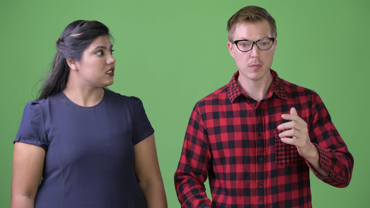 joven pareja de negocios multiétnica juntos contra un fondo verde