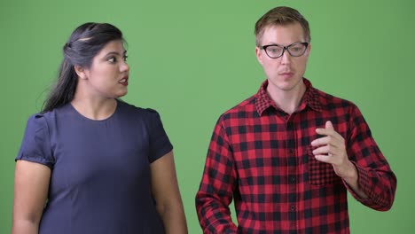 joven pareja de negocios multiétnica juntos contra un fondo verde