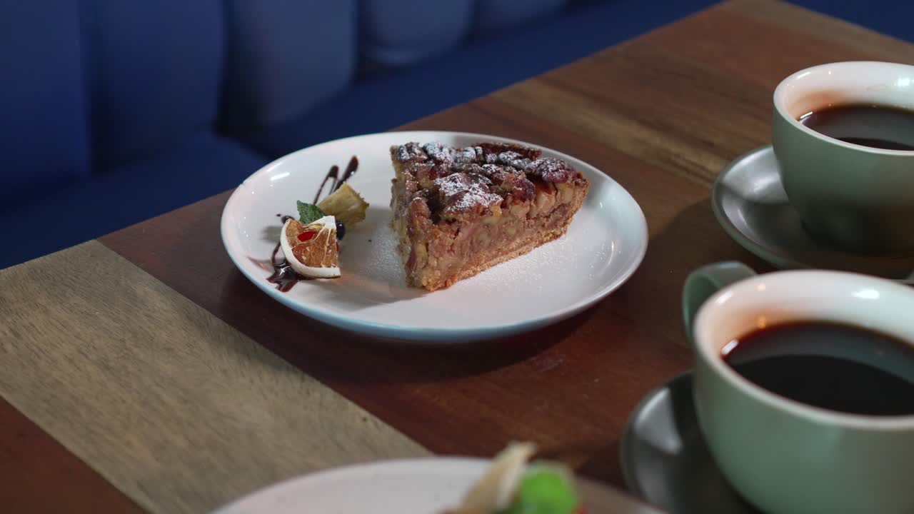 postre de pastel de nueces en una mesa de restaurante, acompañado de dos tazas de café