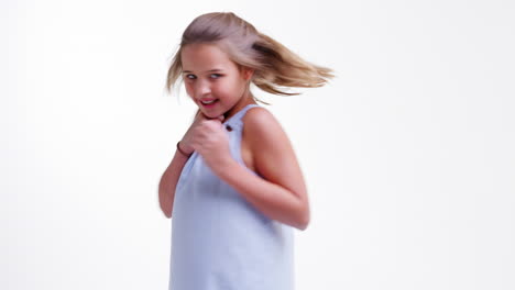 chica saltando y posando contra el fondo blanco del estudio