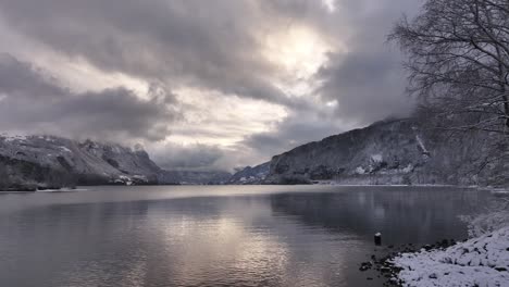 drones aéreos sobre el lago walensee, walenstadt, suiza, árboles cubiertos de nieve y majestuosas montañas de invierno.