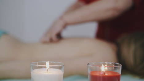 girl massage therapist works with young client back in salon