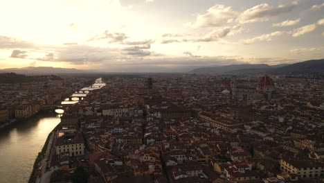 aerial flyover of arno river and skyline of florence old town, italy
