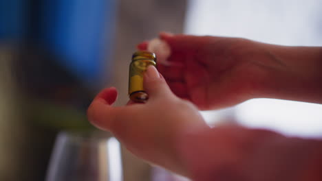 woman opens and examines brown bottle of poisonous powder