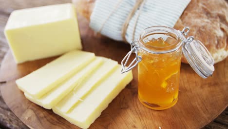 bread loaf with slices of cheese and sauce on wooden serving board