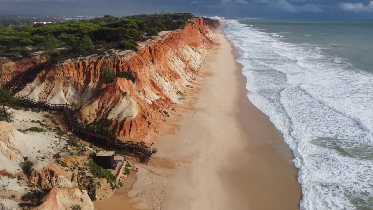 incredibile droneshot della lunga spiaggia di sabbia rossa di falesia nel sud del portogallo, tempo soleggiato e belle onde