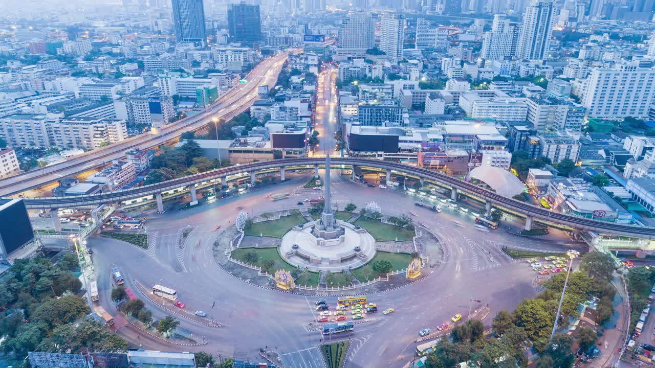 Time-lapse or Hyper-lapse Dusk to day Aerial view highway and 4 way road stop circle or intersection traffic at night with cityscape for transportation concept