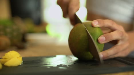 close up of female hands cutting a mango