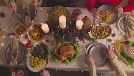 Top-View-Of-Group-Of-Friends-Or-Family-Eating-At-Festive-Christmas-Table