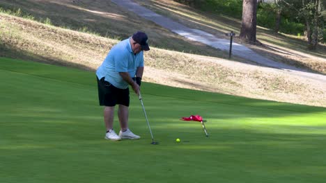 a golfer tries to putt the ball, but he hits it a little too hard and misses