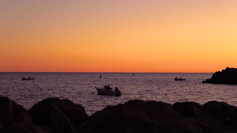 La-Silueta-De-Un-Pez-En-Un-Pequeño-Bote-Frente-A-La-Costa-Durante-Una-Puesta-De-Sol-Naranja-Mientras-Arrojan-Cañas-De-Pescar-Al-Océano-Y-Pescan-En-El-Valle-De-La-Gran-Isla-Canaria-4k-Captura-En-Cámara-Lenta-A-60fps