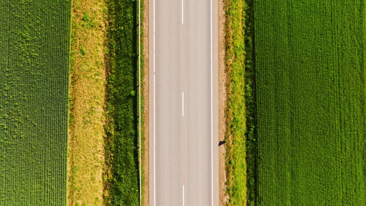 Aerial static timelapse with low shutter speed shows motion blur on rural road