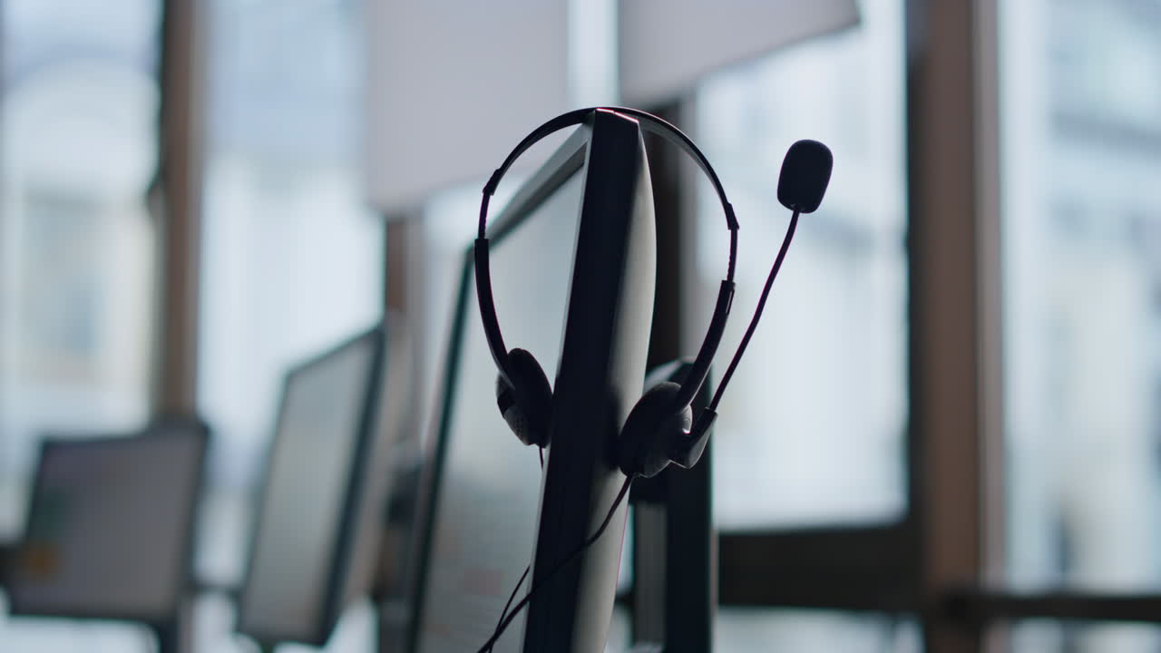 Closeup hand taking headset at call center. Technical support equipment hanging