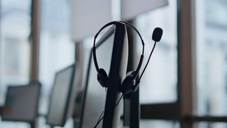 closeup hand taking headset at call center. technical support equipment hanging